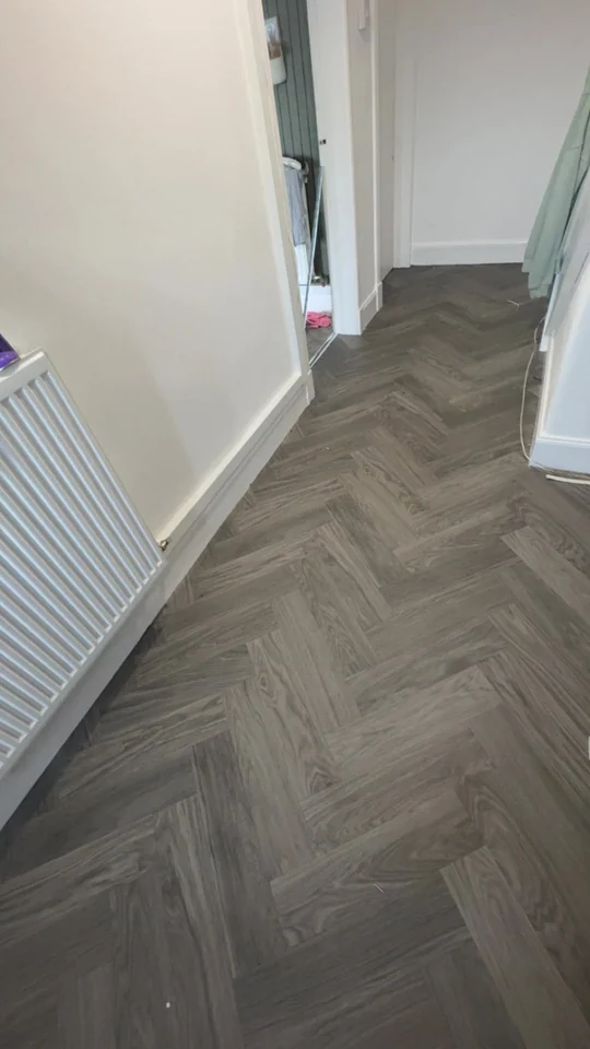 Grey herringbone-style vinyl flooring in a hallway